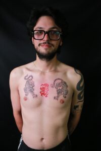 A symmetrical chest tattoo featuring two fierce tigers facing each other in traditional black and grey style, symbolizing power and protection.